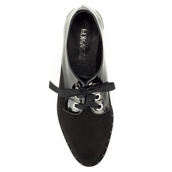 Fekete Lukasz fűzős női cipő nubuk és lakk bőr kombinálásával. Talpa körben szegecsekkel díszített, fűzője szatén. Bélése bőr, sarka 2,5 cm magas.